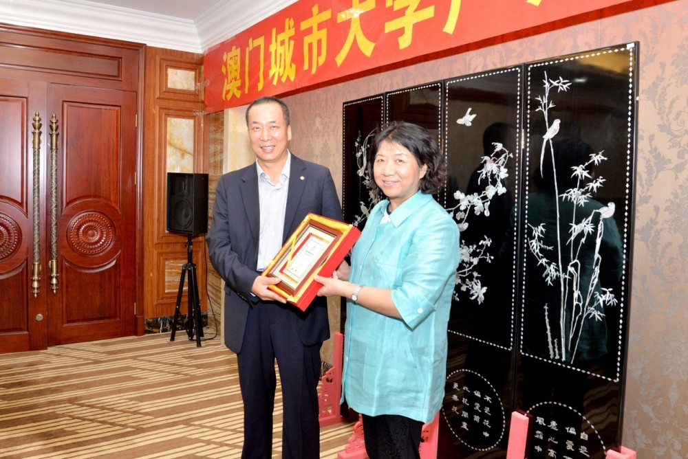 Prof. Kong delivers a souvenir to Dr. Zhou Yifeng